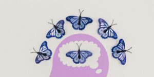 Purple thought bubble with butterflies: six blue butterflies arranged around central butterfly inside bubble.