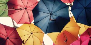 A vibrant arrangement of open umbrellas in red, blue, yellow, pink, and green, suspended above and creating a cheerful overhead canopy.