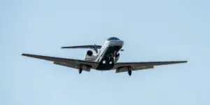 Sleek private jet landing against a clear sky, symbolizing discreet, high-end transport to a luxury rehab center.