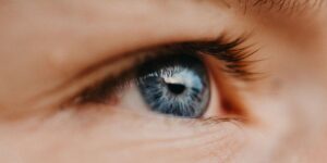 An extreme close-up of a person's blue eye, illustrating the focal point of Eye Movement Desensitization and Reprocessing (EMDR) therapy, an evidence-based psychological treatment used to help individuals heal from severe trauma and emotional triggers underlying their substance addiction.